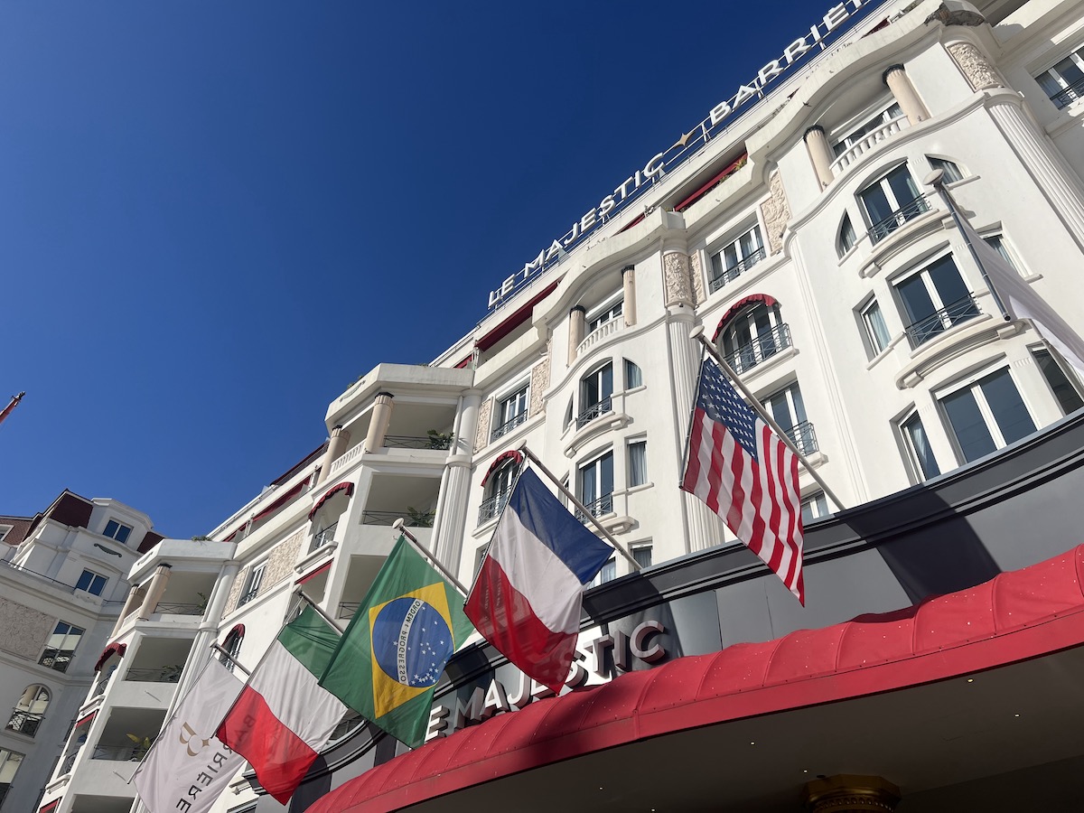 Outside of the Majestic hotel, an art deco building with flags flying in the wind