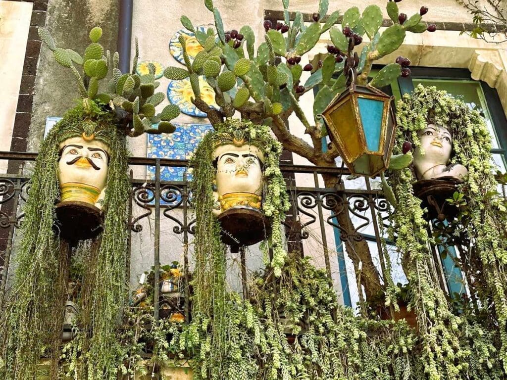 Taormina has many balconies with plants growing down out of plant pot heads called teste de moro