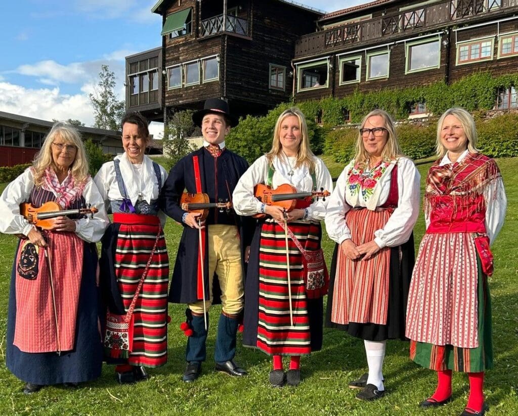 Musicians and local people proudly wear their traditional costume in front of the Green Hotel, Dalarna, Sweden